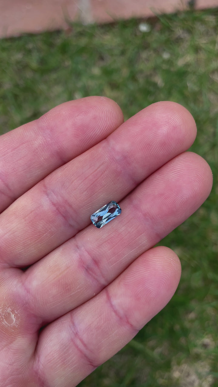 A close-up video of a blue sapphire with an elongated geometric cushion cut, showcasing its facets and reflections. The gemstone weighs 1.26 carats and originates from the Umba River, Tanzania.