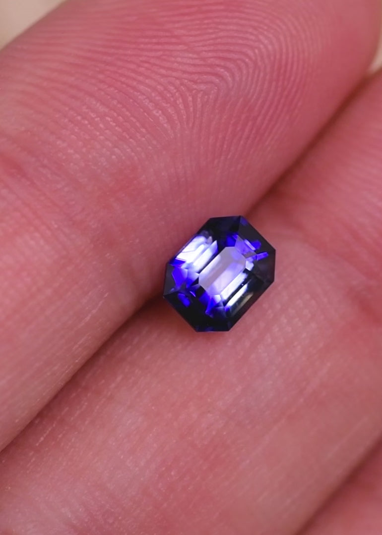 Rotating loose blue bi-color sapphire emerald cut from Sri Lanka displaying the contrast between the deep blue body color and lighter colorless areas.