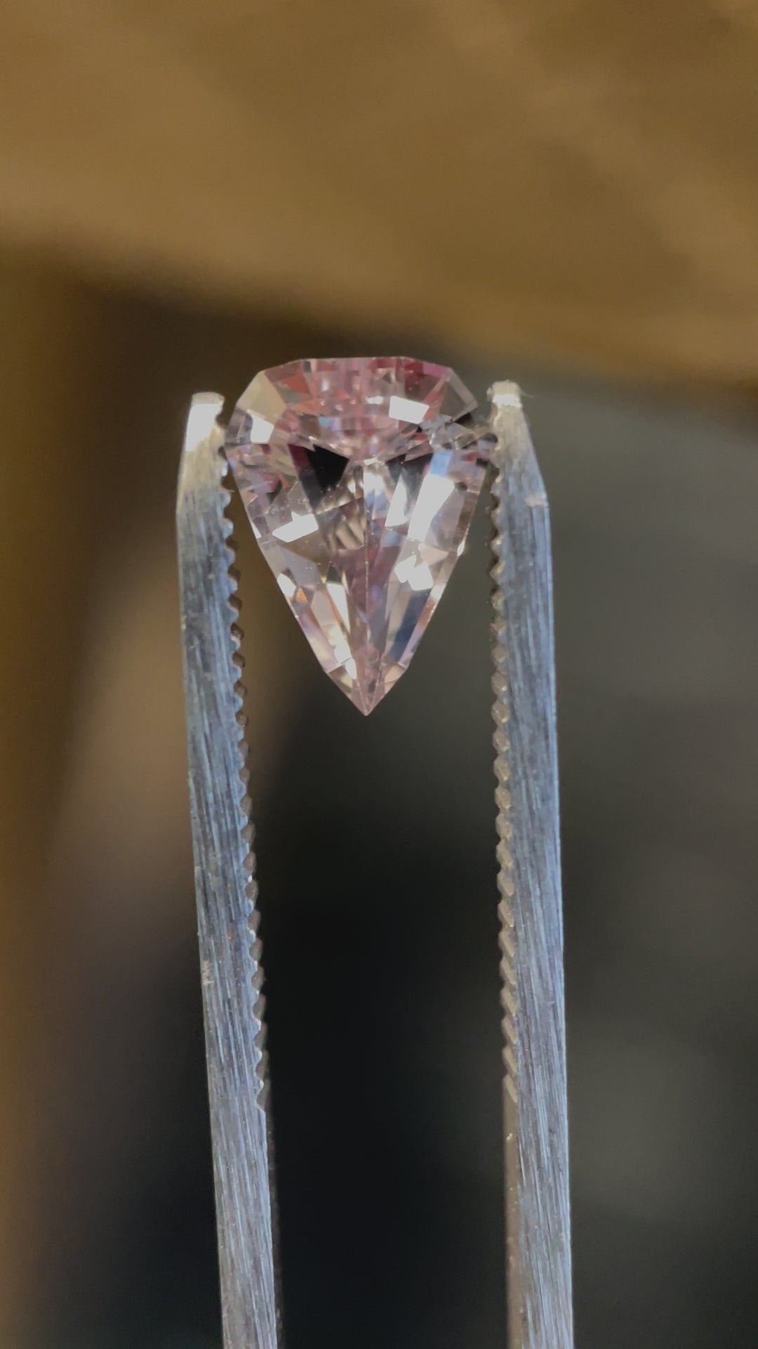 A captivating video of a 2.09-carat sapphire from Sri Lanka, showing its natural color change from pink to peach in a custom step cut shield design. No enhancements.