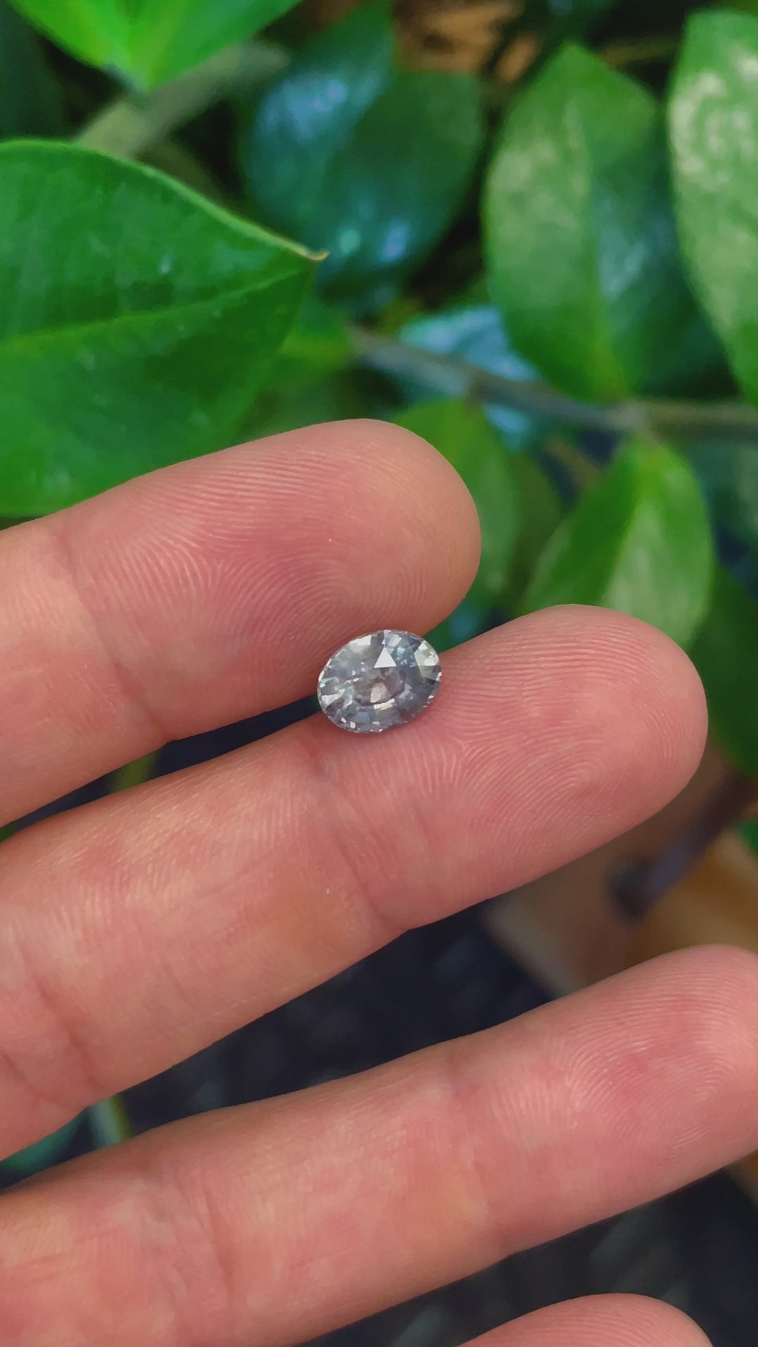 Close-up video of a 3.19 carat teal and seafoam sapphire, mix brilliant oval cut, showcasing its pristine facets and vibrant color shift, ideal for high-end jewelry.