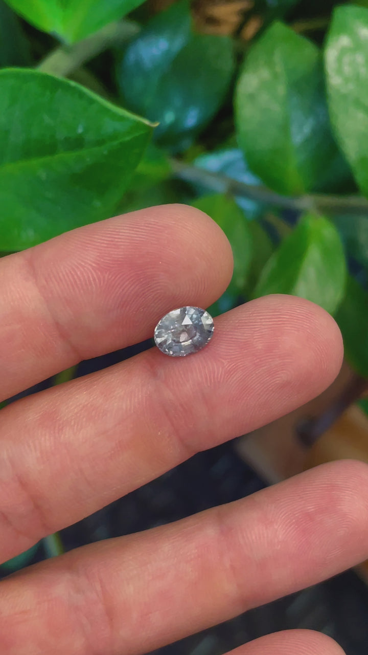 Close-up video of a 3.19 carat teal and seafoam sapphire, mix brilliant oval cut, showcasing its pristine facets and vibrant color shift, ideal for high-end jewelry.