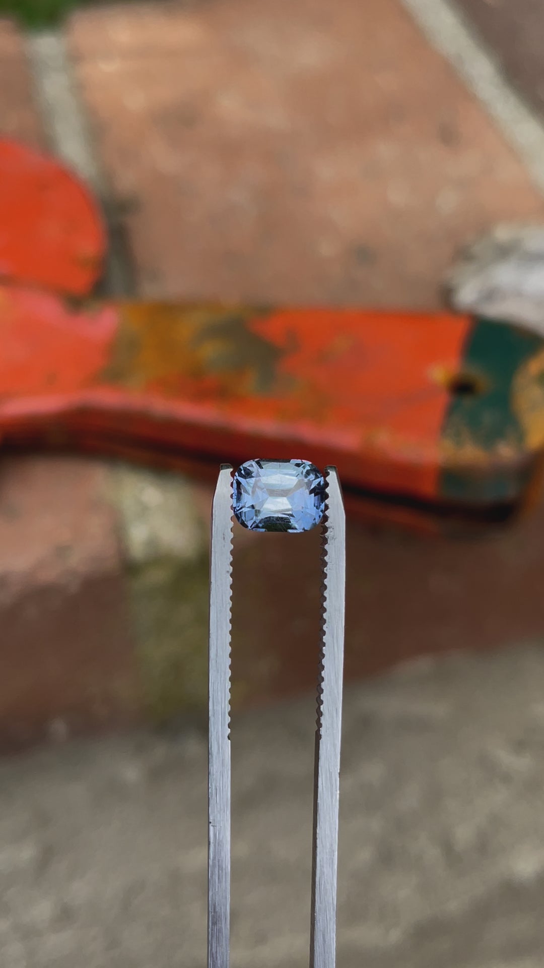 A close-up video of a 1.42-carat sapphire with a classic precision cushion cut, exhibiting a color shift from teal indigo to violet, sourced from the Umba River, Tanzania. The sapphire is rotated to showcase its brilliance and color variation.