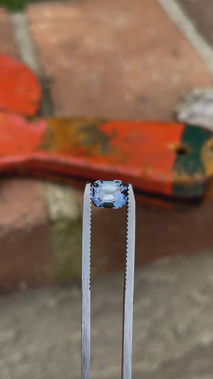A close-up video of a 1.42-carat sapphire with a classic precision cushion cut, exhibiting a color shift from teal indigo to violet, sourced from the Umba River, Tanzania. The sapphire is rotated to showcase its brilliance and color variation.