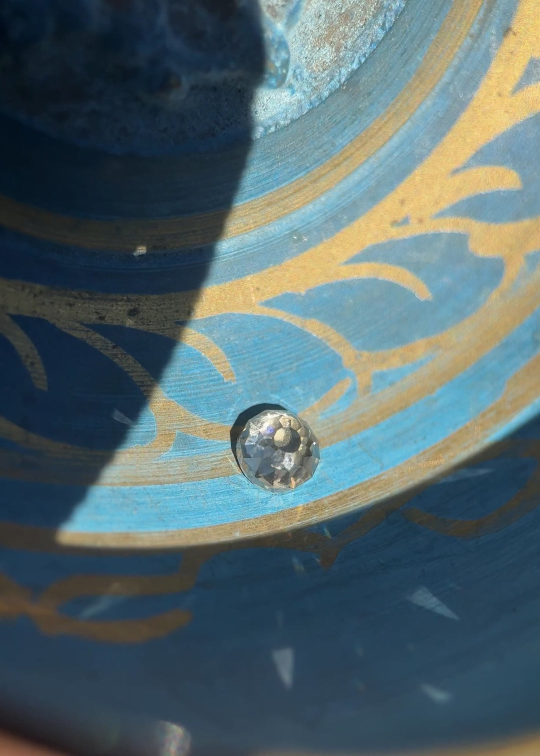 Video of 0.83ct Fancy Light Brown C2 VVS1 Mughal Cut Diamond on blue background under natural and fluorescent lighting, showing strong blue fluorescence, antique-style faceting, and brilliance from South African untreated diamond.