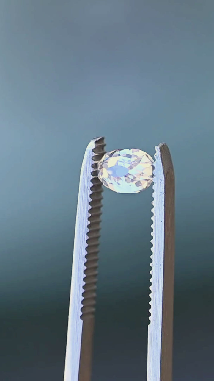 Oval Mughal cut South African diamond rotated between jeweler’s tweezers, showing its profile, elongated proportions and changing mosaic of reflections across the facets.
