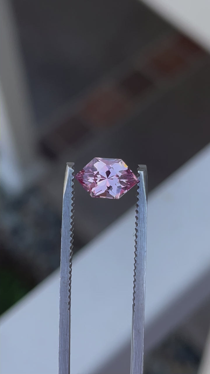 Detailed footage of a 1.61 carat blush pink and peach sapphire, focusing on the modified brilliant hexagon cut. The video showcases the gemstone's peachy-pink hues and exceptional clarity from different angles.
