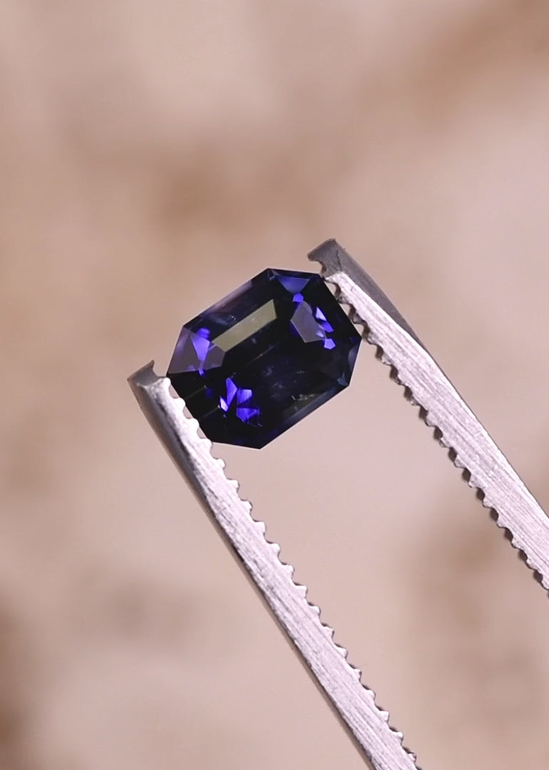 Rotating loose blue bi-color sapphire from Ratnapura Sri Lanka showing the brilliance and step facets of the emerald cut as the blue and colorless zones shift in light.