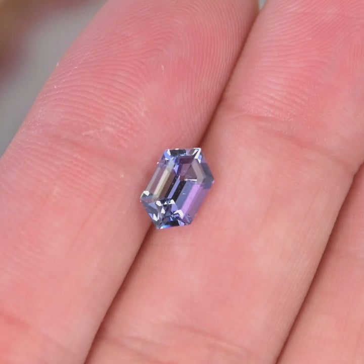 Close up video of 1.24ct Tanzanite hexagon cut gemstone displaying step cut sparkle geometric symmetry and trichroic teal blue purple hues