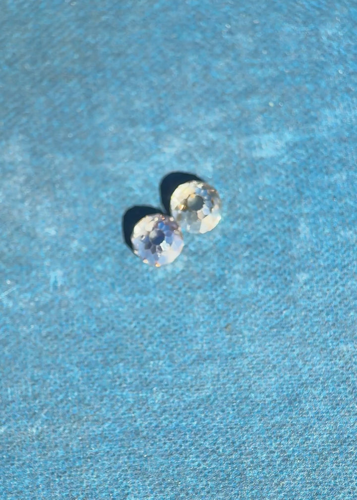 Video of a matched pair of Mughal cut diamonds rotating under controlled lighting, showcasing antique faceting, fancy brown color, VVS clarity, and strong blue and yellow fluorescence in untreated South African diamonds.