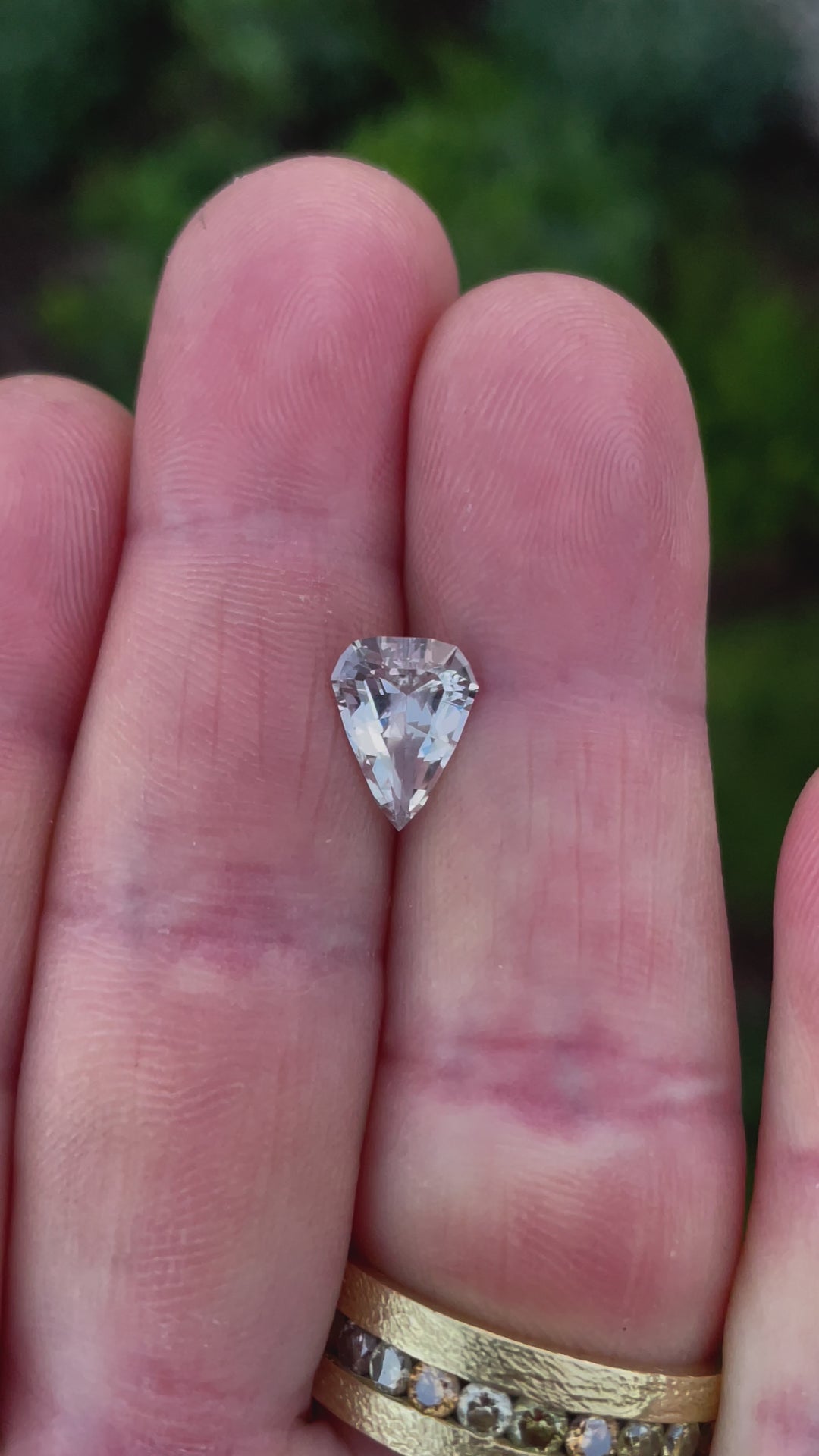 Close-up video highlighting a 2.09-carat Sri Lankan sapphire, exhibiting a unique color change from pink to peach. Crafted in a modified shield step cut, untreated.