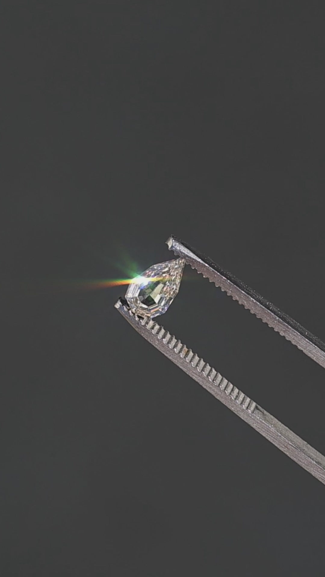 0.89ct Geo Pear Step Cut Champagne Diamond held in gem tweezers rotating under direct sunlight showing off impressive sparkle and unique shape.