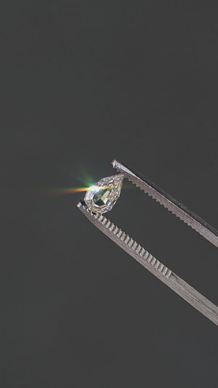 0.89ct Geo Pear Step Cut Champagne Diamond held in gem tweezers rotating under direct sunlight showing off impressive sparkle and unique shape.