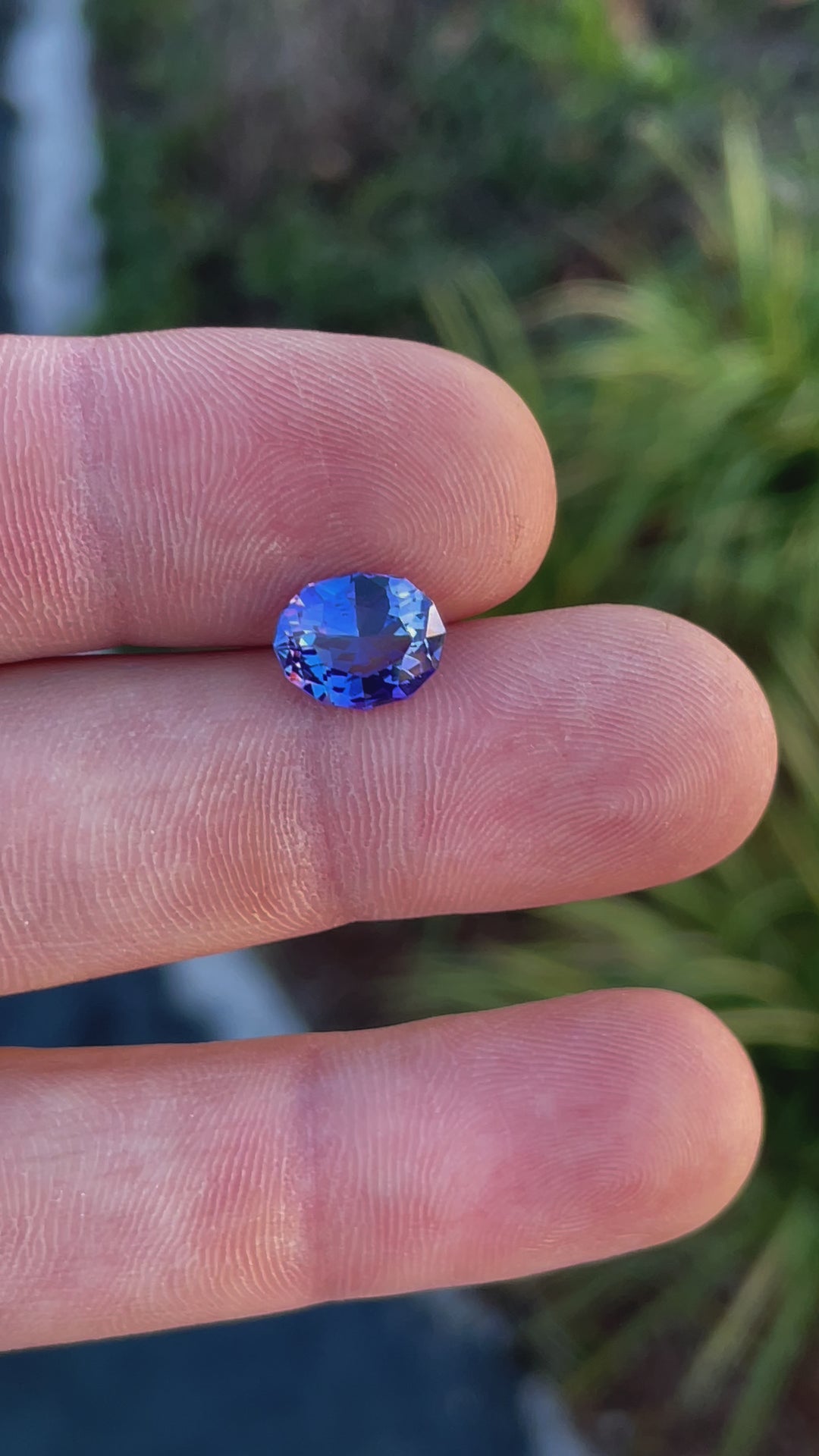 Video of a 3.32-carat tanzanite gemstone in a custom geometric oval cut, displaying its vivid ultra violet and blue colors in different angles.