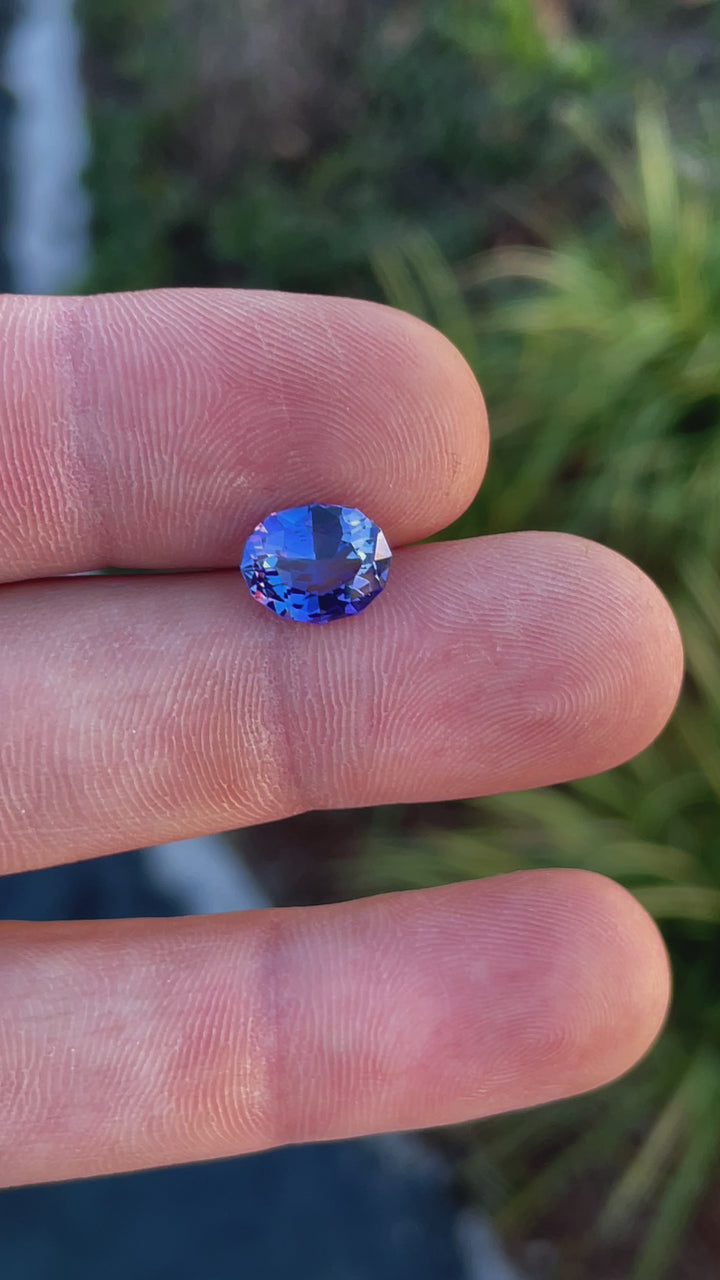 Video of a 3.32-carat tanzanite gemstone in a custom geometric oval cut, displaying its vivid ultra violet and blue colors in different angles.