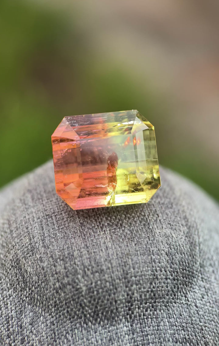 43.06 carat Mozambique tourmaline close up showing emerald step cut facets and natural multi color zoning in yellow green orange pink tones