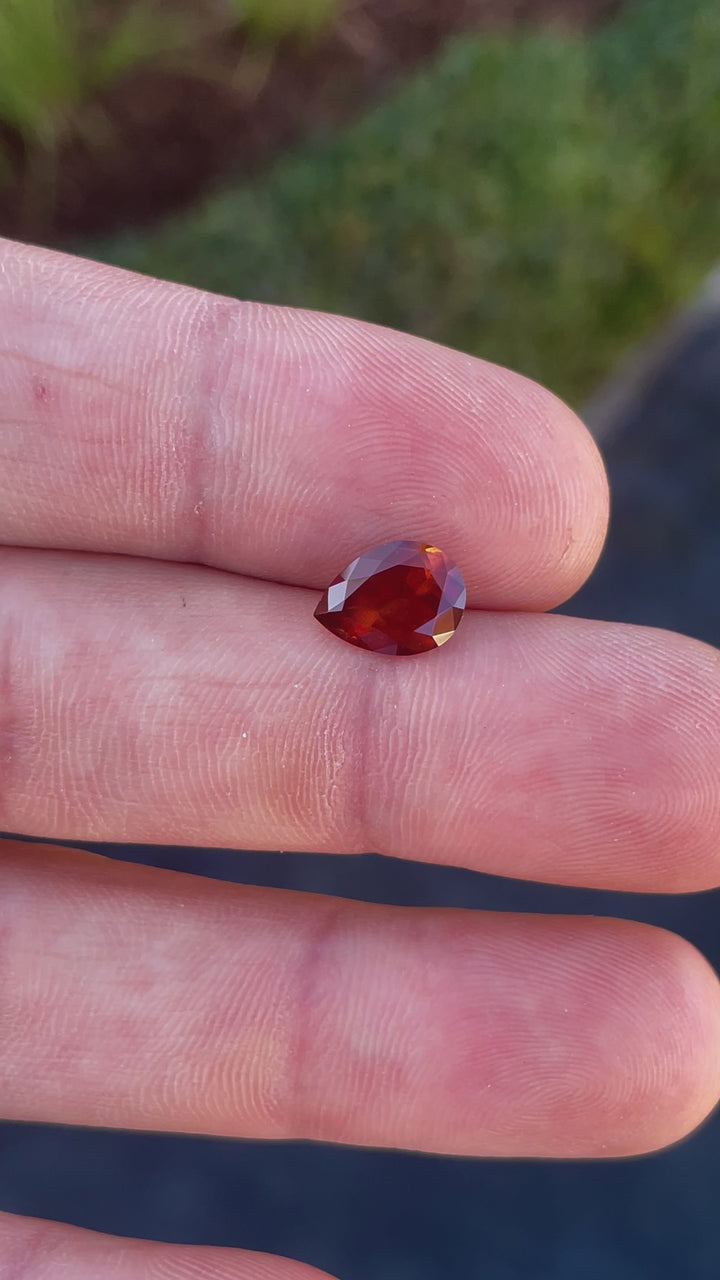 A video showcasing a stunning 2.90-carat orange-red-yellow pear-cut sapphire being rotated to highlight its sparkle and natural Tanzanian beauty.