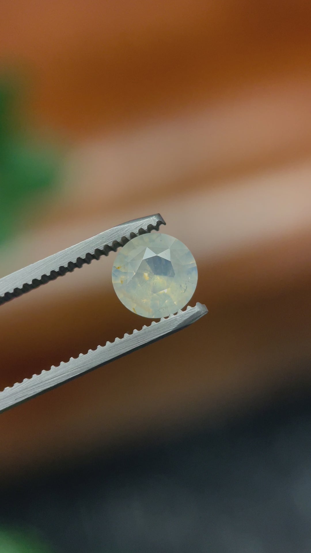 360-degree video of a 2.08 carat round brilliant cut sapphire gemstone, showcasing opalescent white to yellow tones, untreated and of Sri Lankan origin.