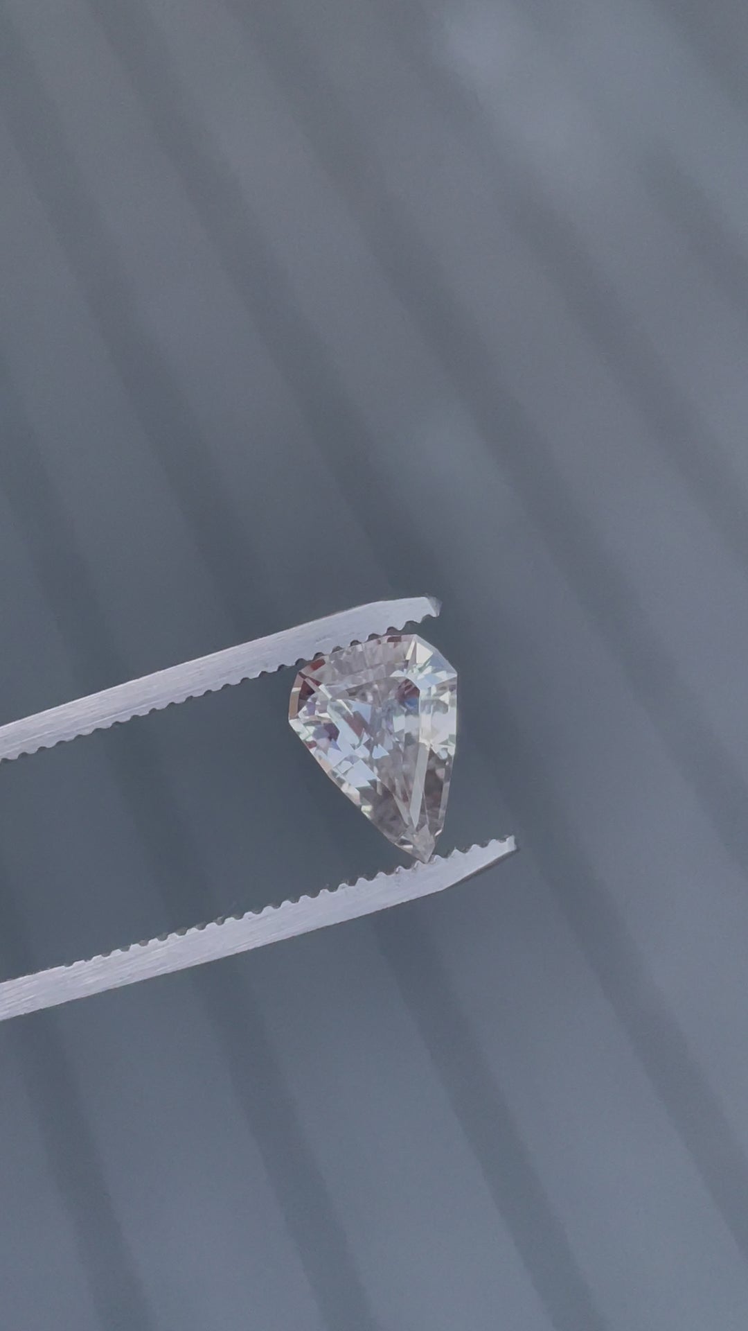 Video showcasing a stunning 2.09-carat sapphire with a color change from pink to peach, in a modified geometric step cut shield shape from Sri Lanka. No treatment applied.