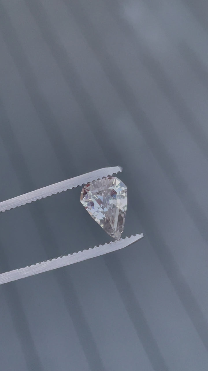Video showcasing a stunning 2.09-carat sapphire with a color change from pink to peach, in a modified geometric step cut shield shape from Sri Lanka. No treatment applied.