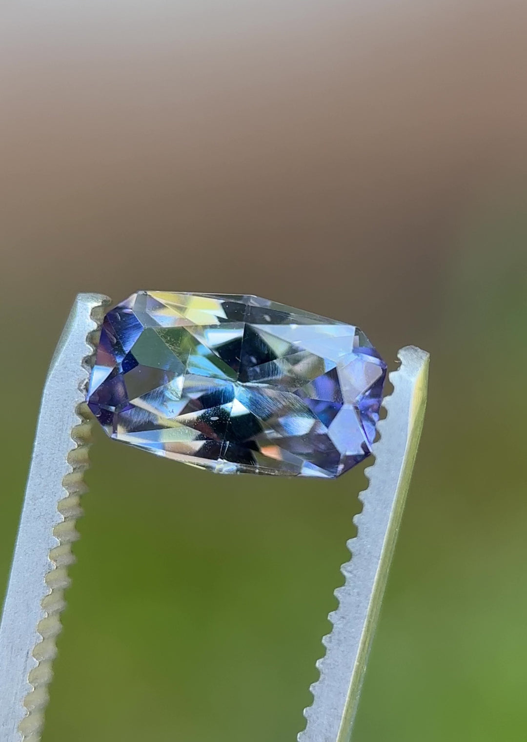 Rotating 360° video of 1.84-carat unheated Tanzanite with vivid teal, lavender, and green reflections in custom cushion cut.
