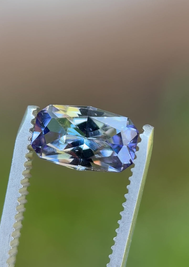 Rotating 360° video of 1.84-carat unheated Tanzanite with vivid teal, lavender, and green reflections in custom cushion cut.