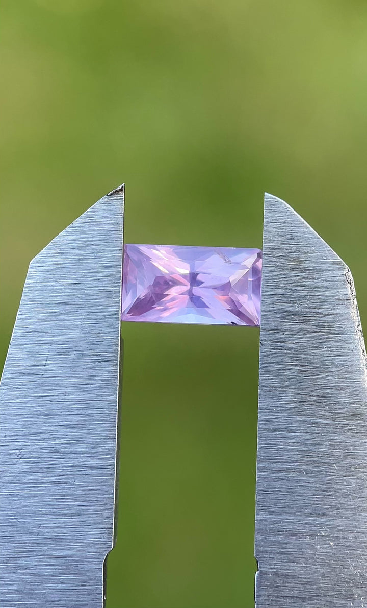 Softly lit video of a 1.53-carat pastel sapphire, showing its opalescent pink and purple colors in motion with crisp baguette faceting.
