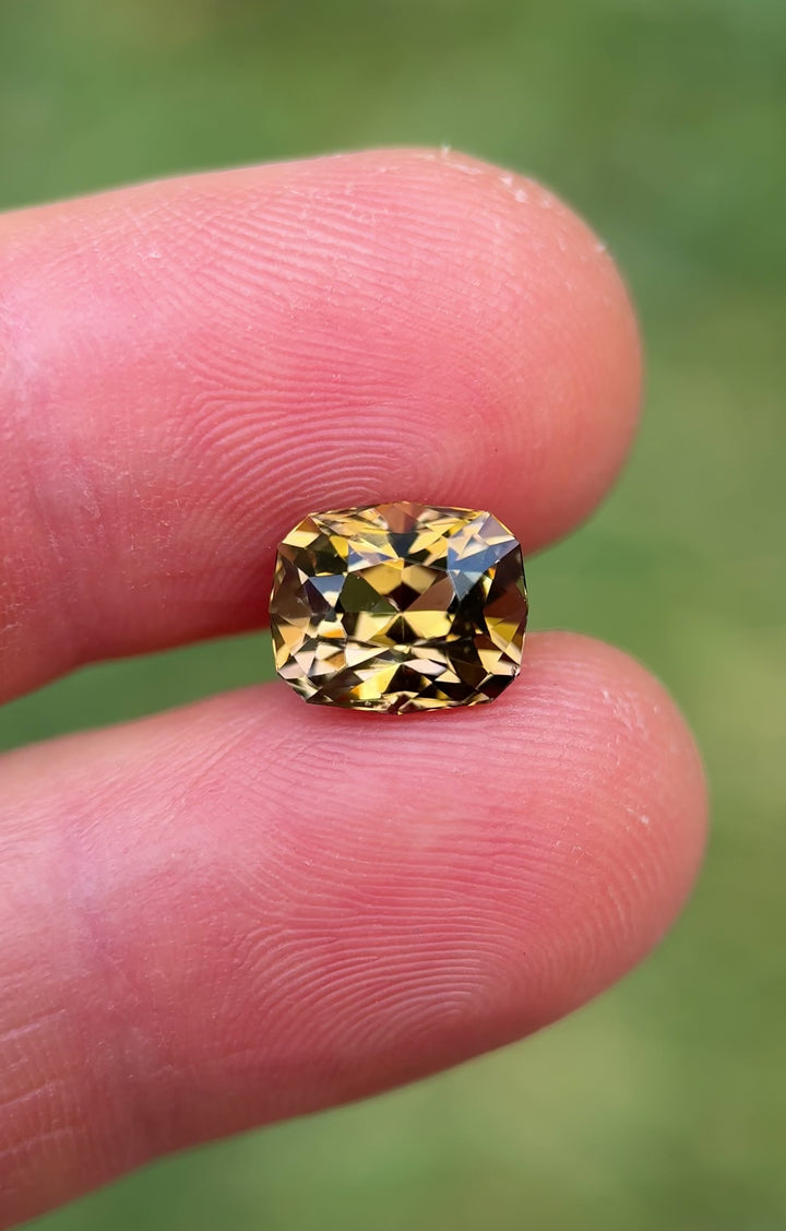 Daylight rotation video of 3.81 carat Tanzanite from Merelani Hills, Tanzania, revealing color play between lavender, pink, and golden yellow through the custom geometric cushion modified brilliant cut, untreated natural gemstone.