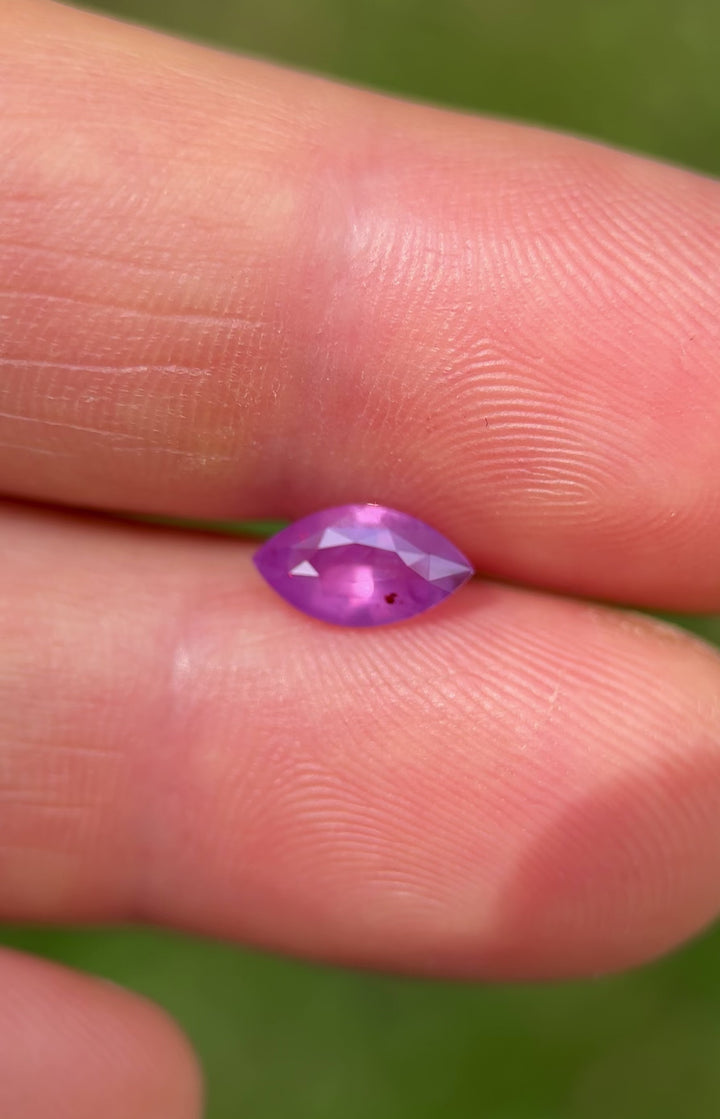 Outdoor video of 1.15CT Sri Lankan sapphire in marquise cut showing light reflection and soft color shift from pink to violet