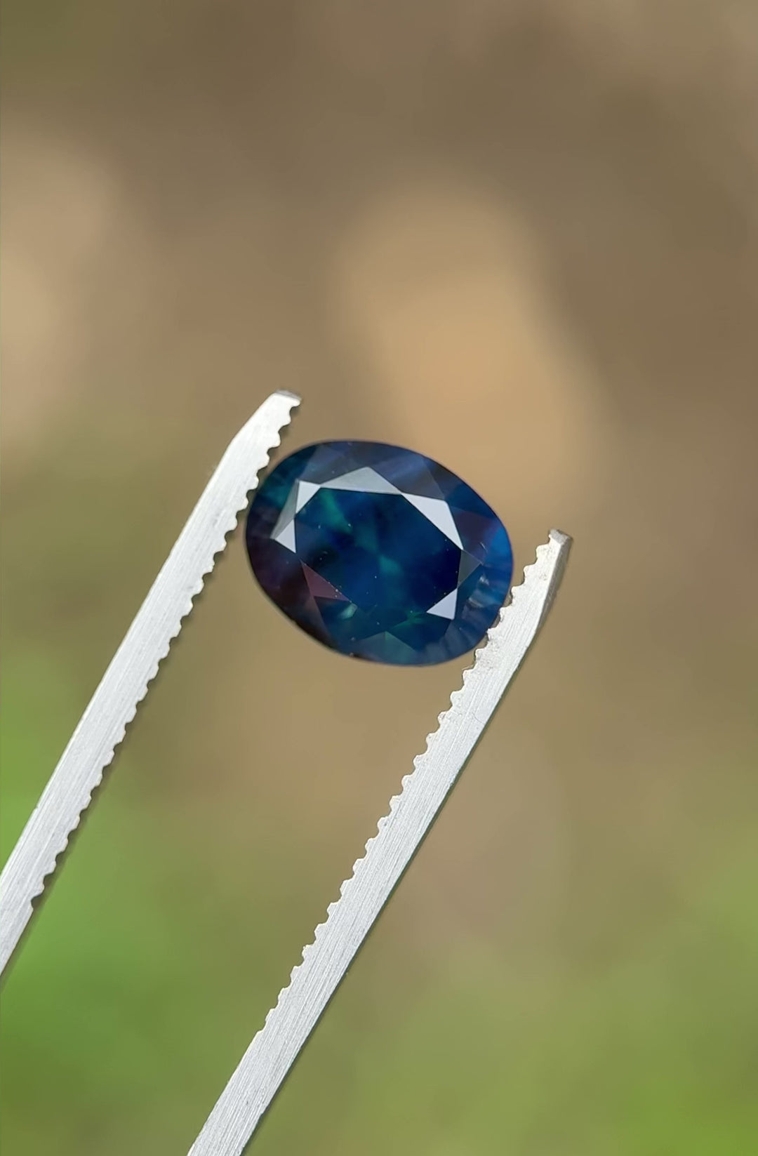 Rotating close-up video of a 3.32ct deep teal blue sapphire, highlighting the gemstone’s silken clarity and light reflection.