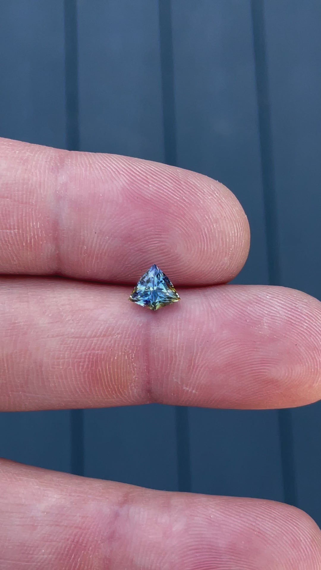 A close-up video capturing the vivid color play and step-cut facets of a Sri Lankan 1.58-carat bi-color sapphire, emphasizing its precision craftsmanship.