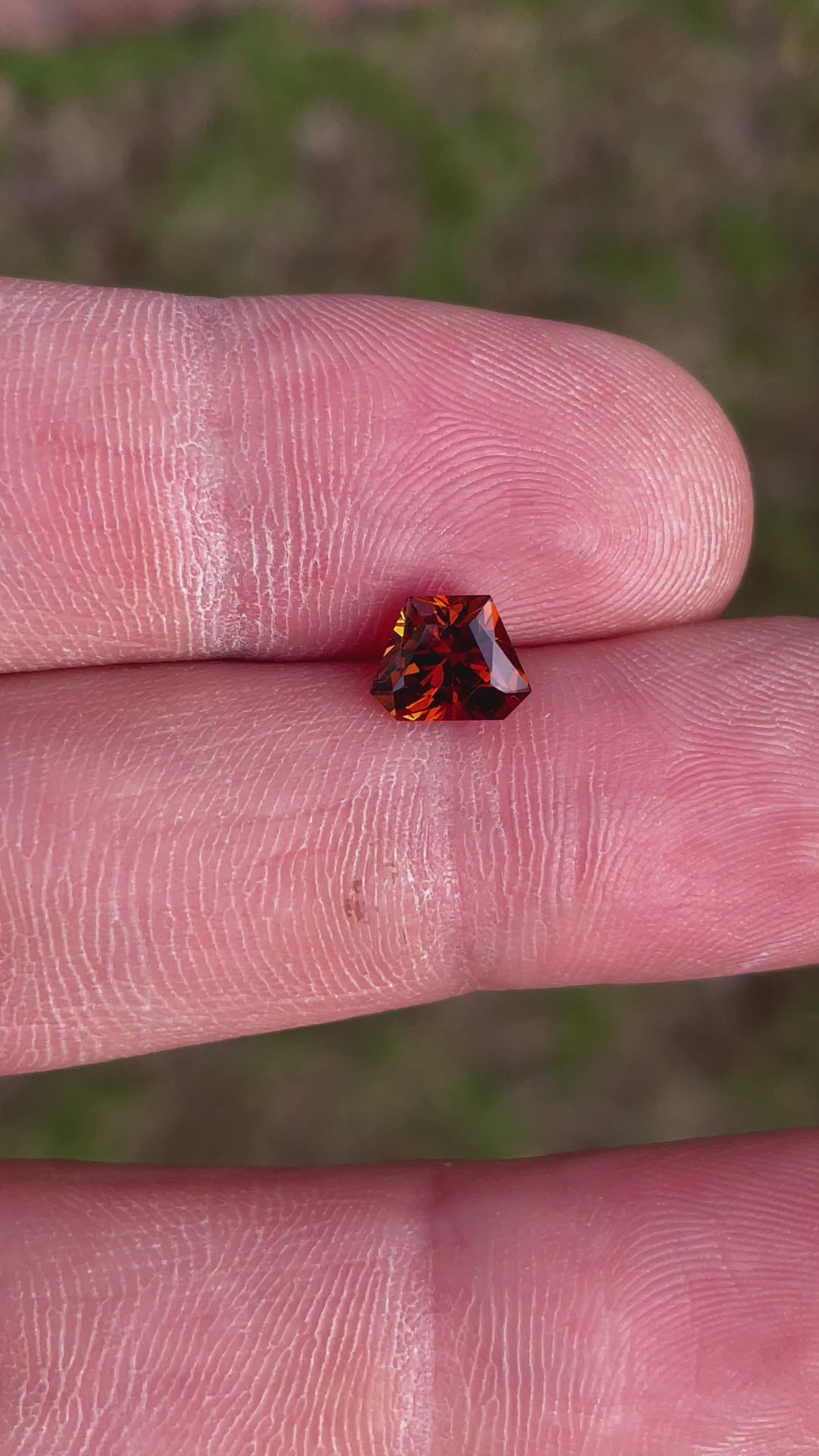 360-degree video of a Hessonite Garnet with a Custom Geometric Shield Cut, weighing 2.00 carats, displaying vibrant yellow, orange, and brown hues, from Kenya.