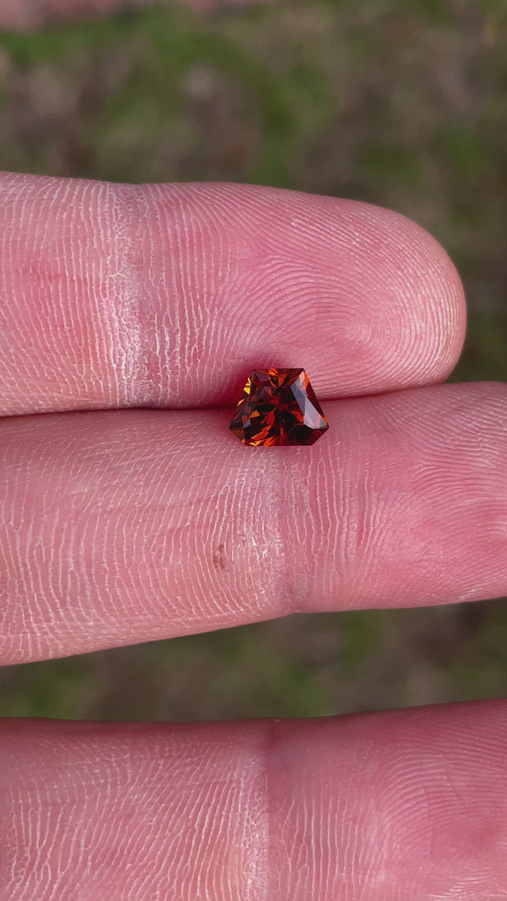 360-degree video of a Hessonite Garnet with a Custom Geometric Shield Cut, weighing 2.00 carats, displaying vibrant yellow, orange, and brown hues, from Kenya.