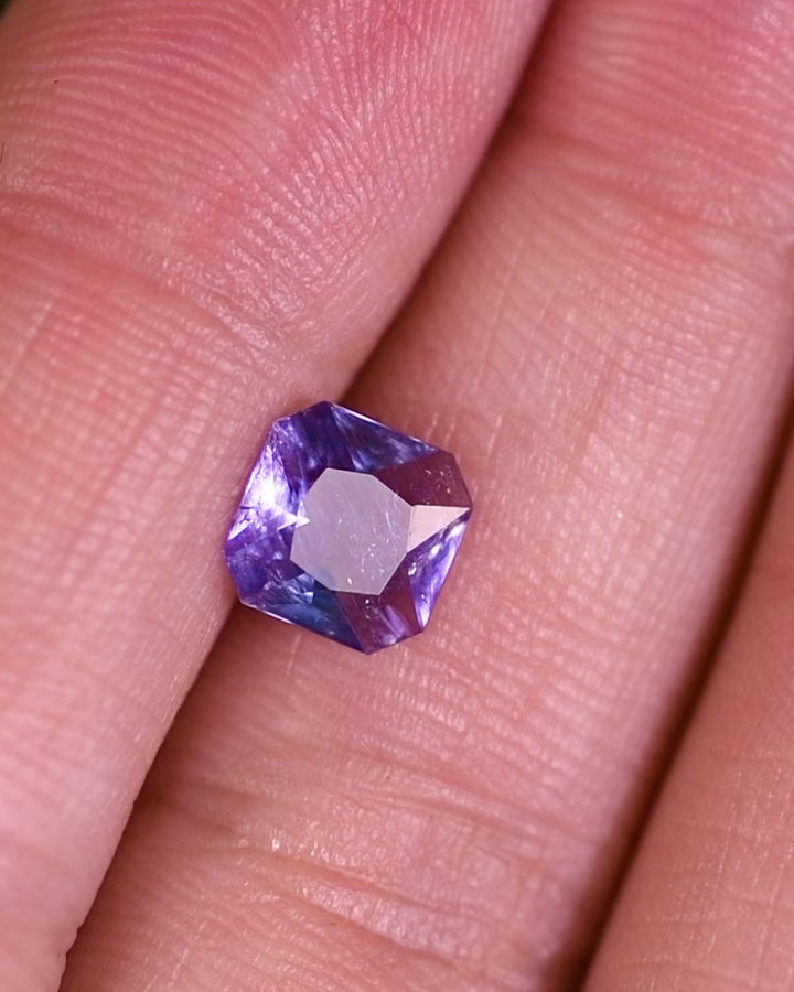 Close-up motion video of 1.26 carat violet blue sapphire under natural light, revealing brilliance, depth, and symmetry of its custom octagonal portrait cut, untreated gemstone from Umba River, Tanzania.