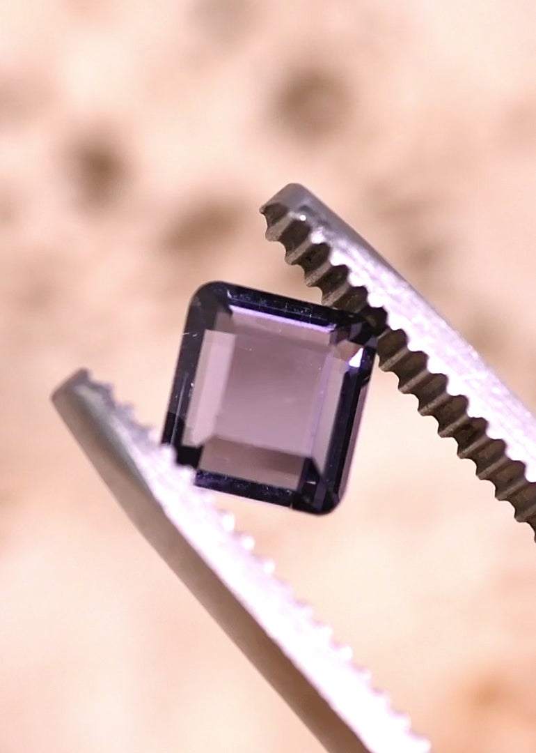1.01 carat untreated purple pink spinel portrait cut shown on fingertip for scale, square geometric gemstone from Sri Lanka with clean step facets