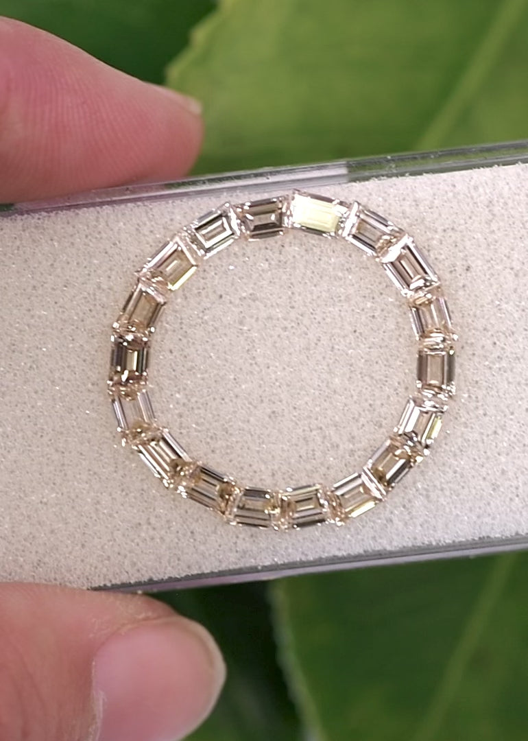 Trapezoid diamond set reflecting light across matching stones showing step cut brilliance.