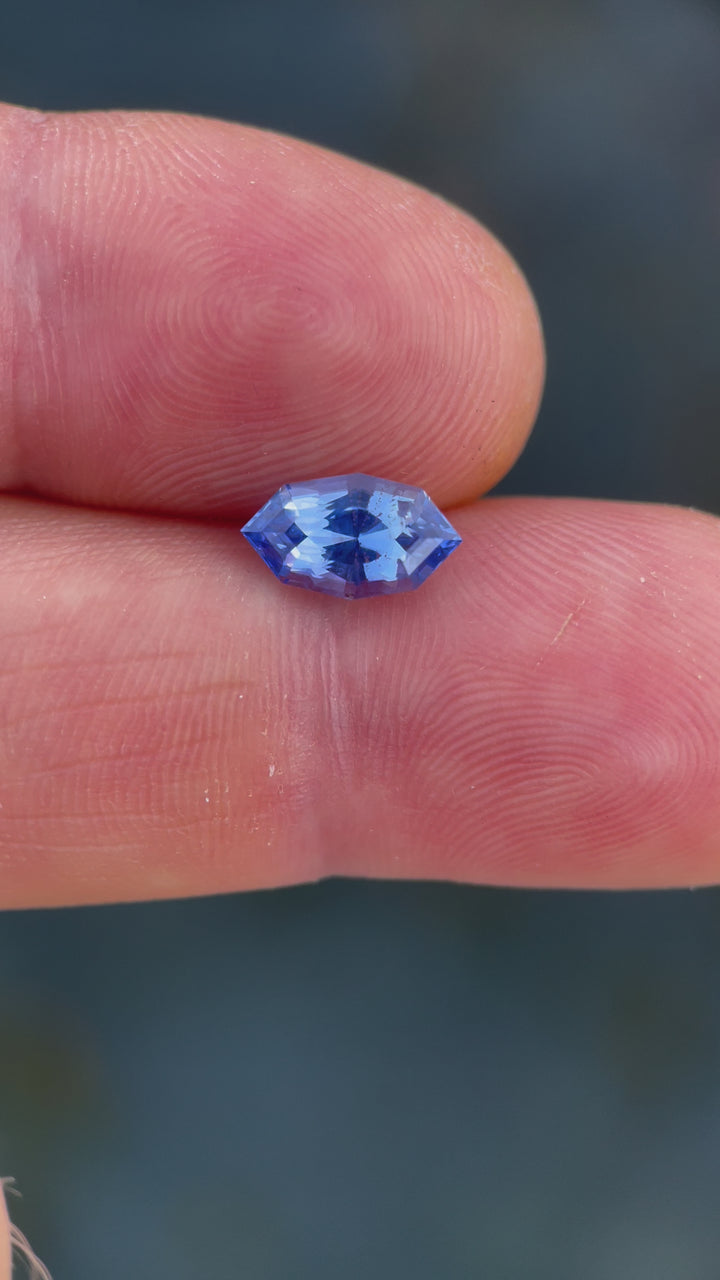 Close-up video capturing the detailed facets and unique parti coloration of a 1.73 carat sapphire, elegantly presented to display its geometric marquise cut and natural beauty.