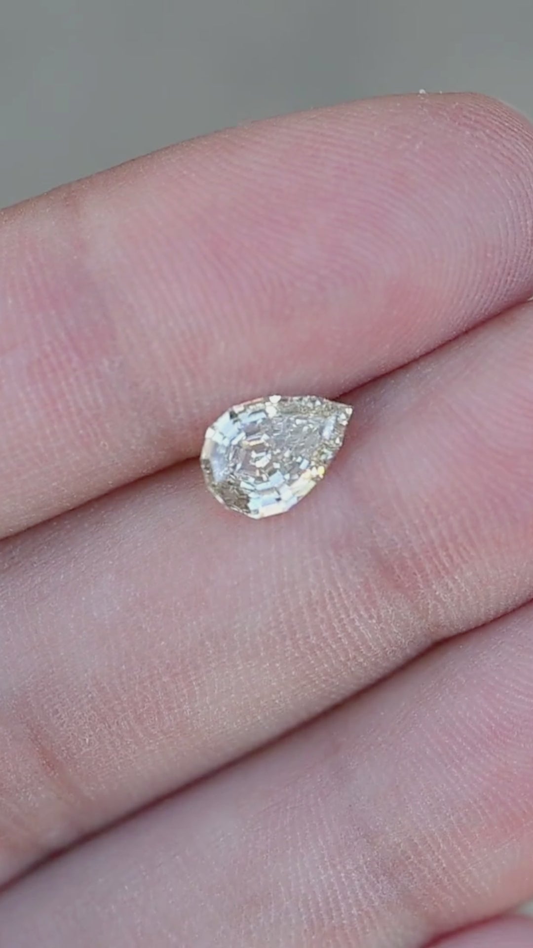 1.20 carat Light Yellow Geo Pear diamond turning slowly in direct sunlight, revealing bright flashes, precision step facets, and elegant architectural brilliance.
