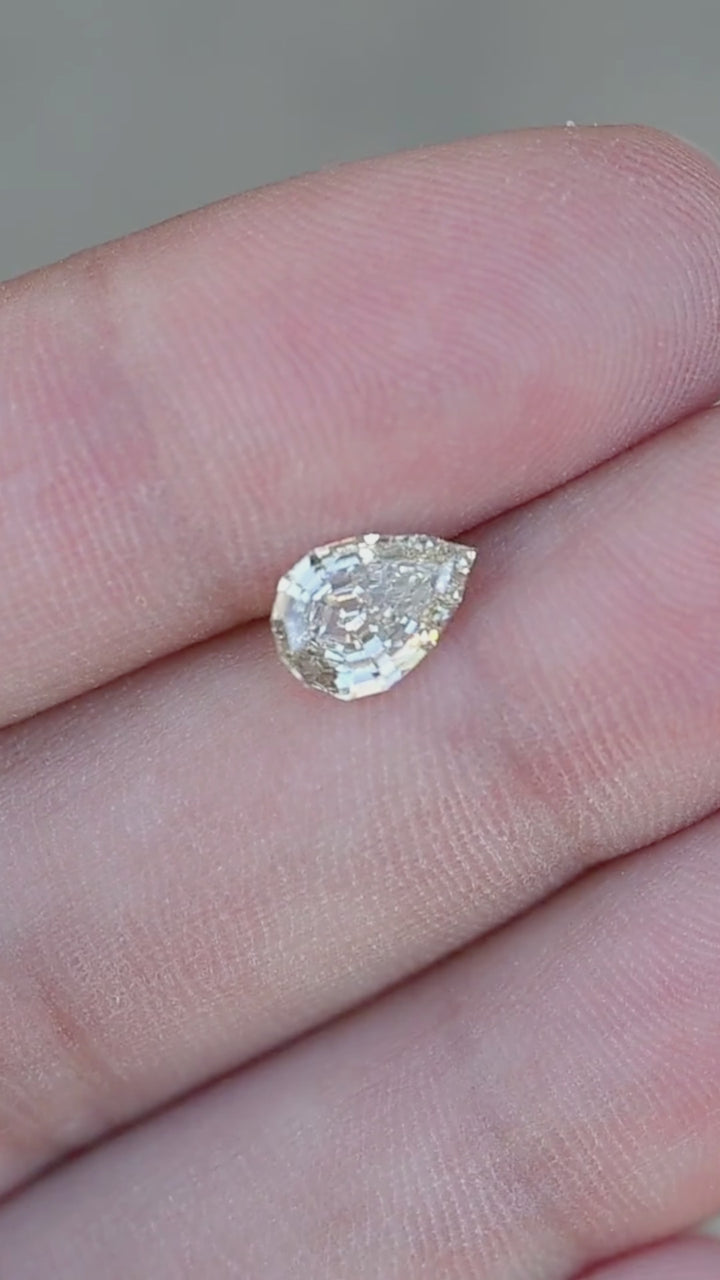 1.20 carat Light Yellow Geo Pear diamond turning slowly in direct sunlight, revealing bright flashes, precision step facets, and elegant architectural brilliance.