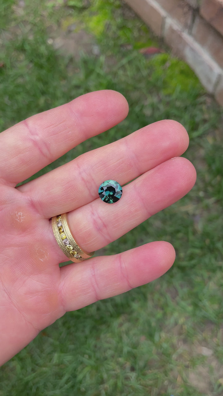 Rotating hand-held video of a 4.00ct sapphire with peacock coloration, highlighting the gem's brilliance and symmetry in outdoor lighting