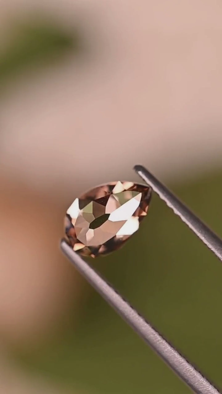 Explore the geometric faceting of a 1.02ct Fancy Orangish Brown Pear Mughal cut diamond from South Africa. Held in jeweler's tweezers, its warm cognac coloration and broad angular facets reveal an architectural character unlike conventional brilliant-cut diamonds. VVS2 clarity, no fluorescence, and no treatment.