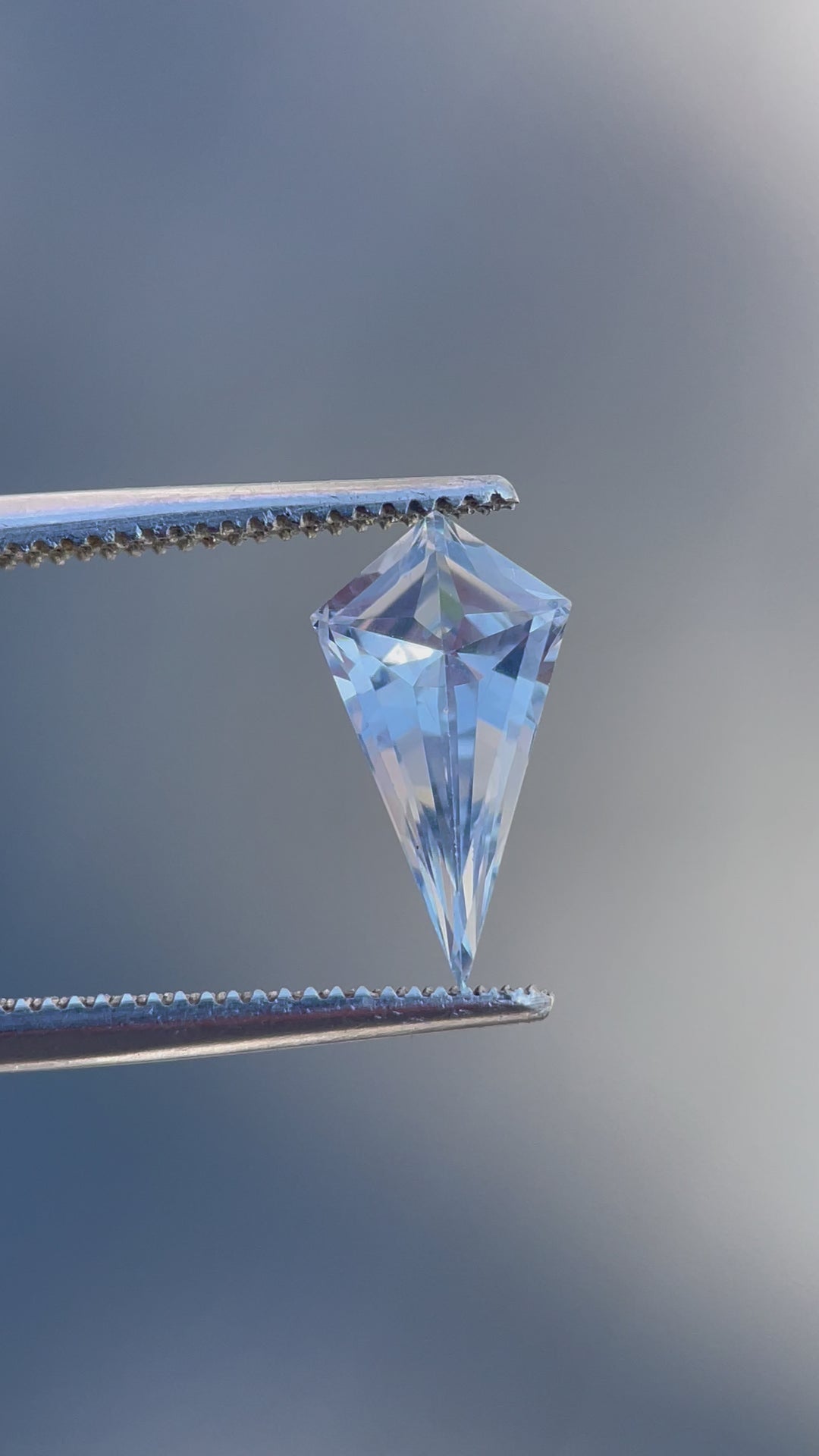 Dynamic view of a geometric step cut kite sapphire, weighing 1.66 carats, focusing on its exquisite color and precision cut, perfect for fine jewelry.