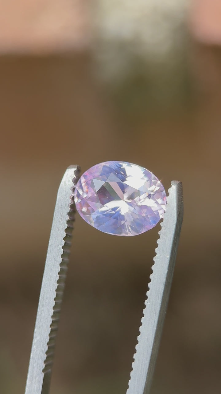 360-degree video of a 2.52-carat natural opalescent pink sapphire in an oval mix cut, rotating in natural light to highlight its soft brilliance and untreated beauty from Sri Lanka.