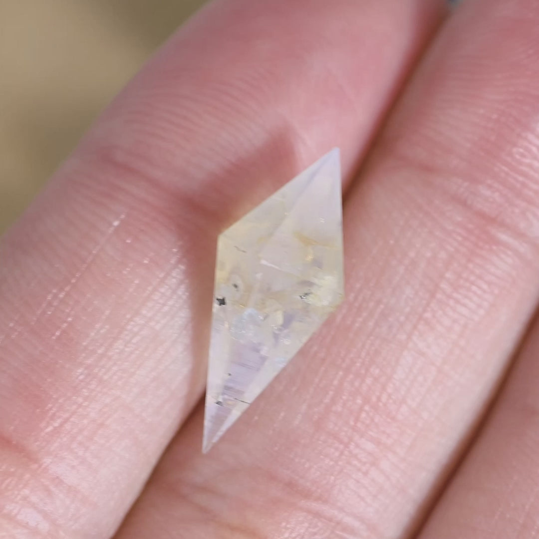 Handheld video of a 6.39 carat natural sapphire from Sri Lanka, displaying its faceted rhombohedral shape, opalescent sheen, and natural crystal character