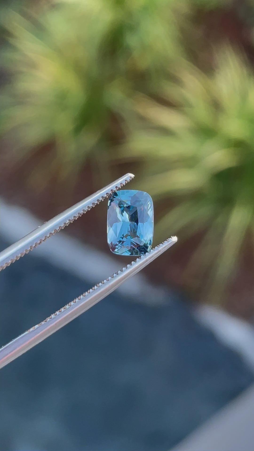 A rotating video of a 1.52-carat denim blue and green cushion-cut sapphire, revealing its intricate facets and clarity.