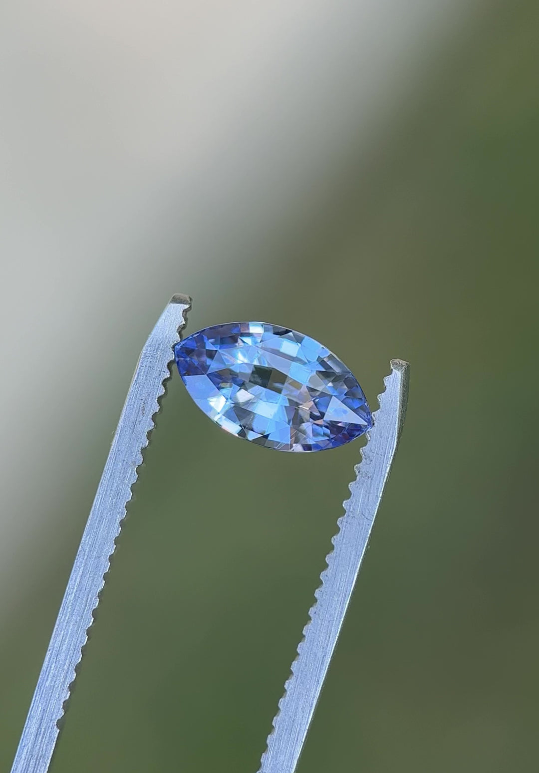 Rotating video of 1.70 carat cornflower blue sapphire with violet undertones from Madagascar, showing precision marquise mixed cut brilliance and untreated natural sparkle under daylight.