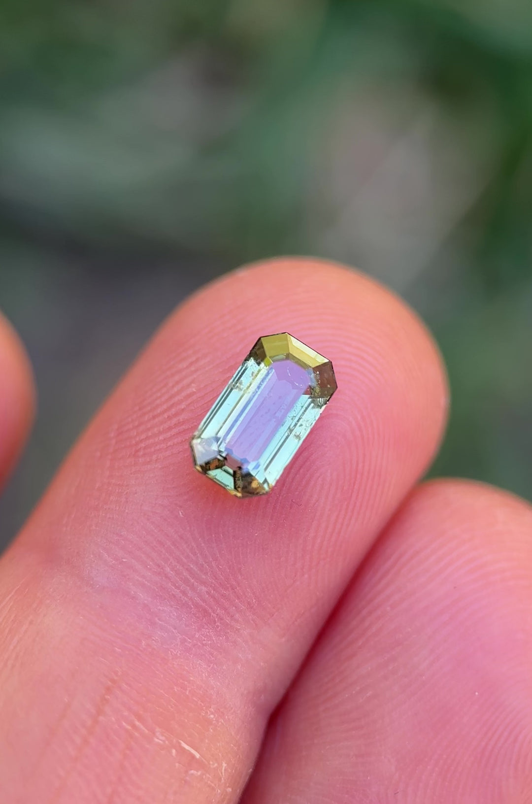 Macro video showcasing sparkle, depth, and earthy green tones of unheated sapphire from Tanzania in emerald cut