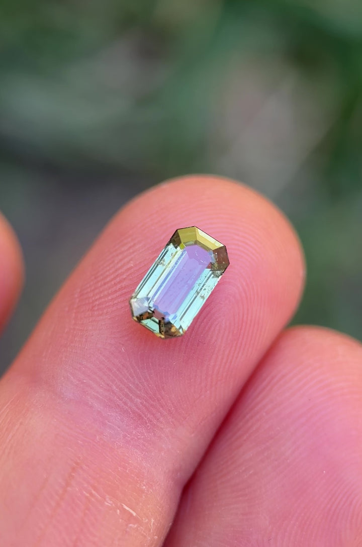 Macro video showcasing sparkle, depth, and earthy green tones of unheated sapphire from Tanzania in emerald cut
