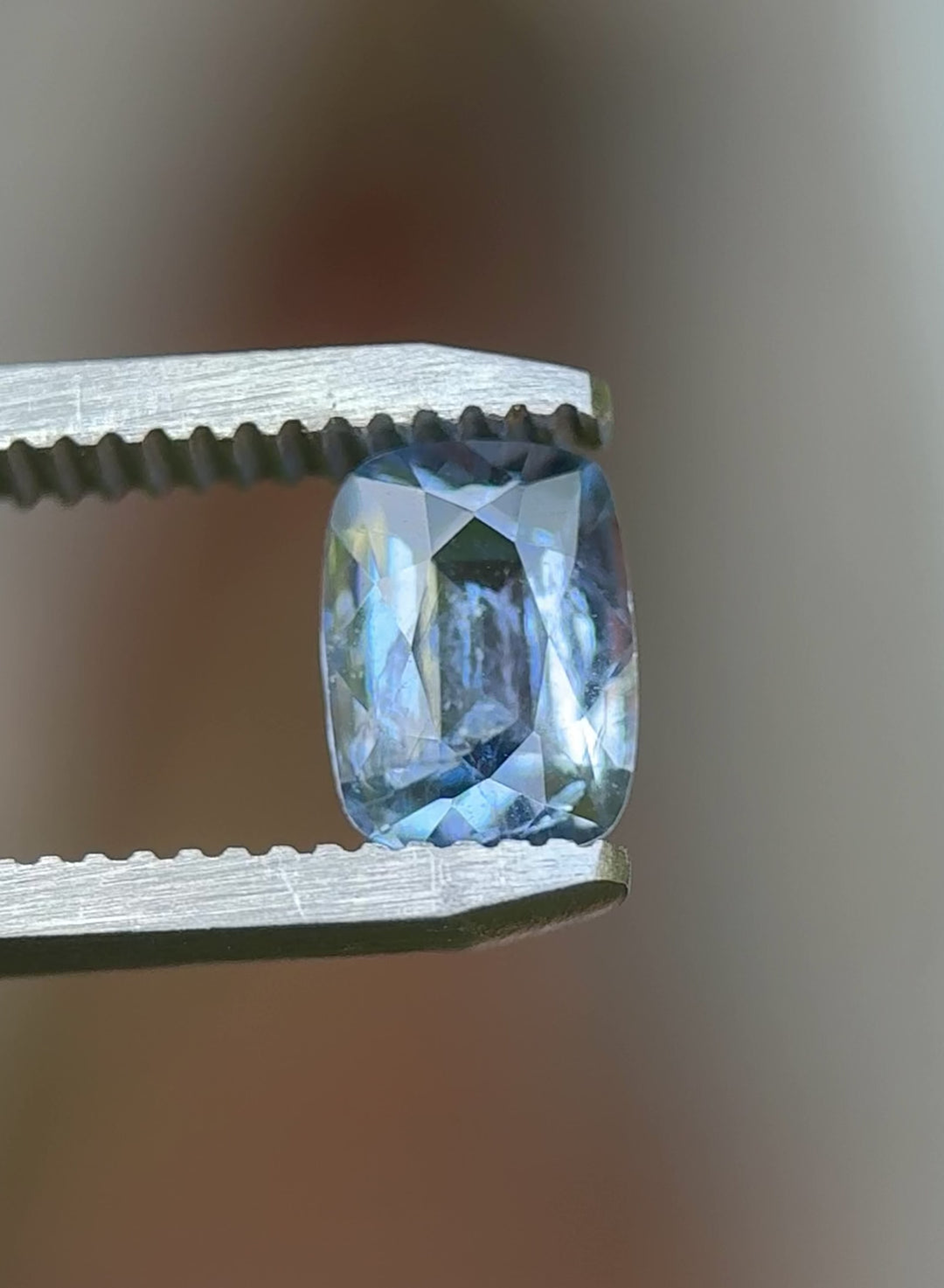 Rotating close-up of a 1.33 carat icy periwinkle blue sapphire in natural daylight, unheated elongated cushion cut from Sri Lanka