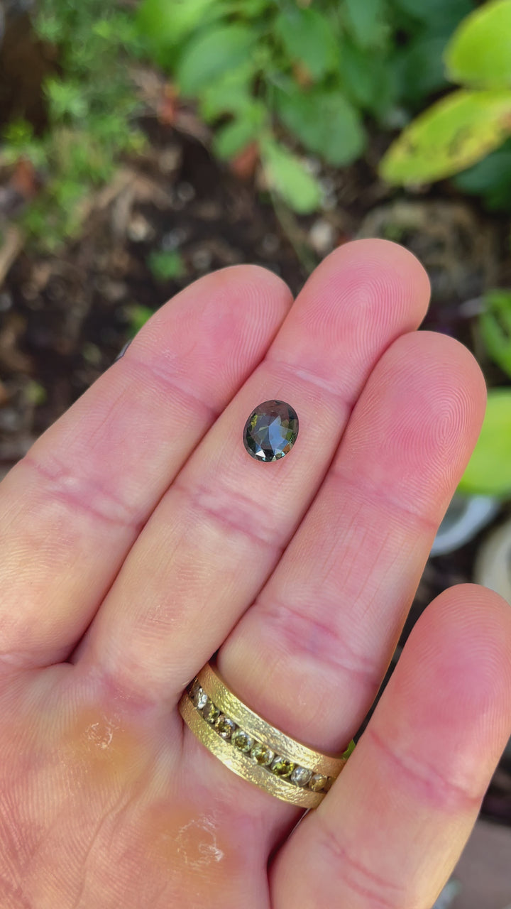 A video capturing the captivating mix of green, blue, and teal hues in a 1.72-carat mix cut oval sapphire. Ethically sourced and untreated, the gemstone showcases remarkable clarity and brilliance.