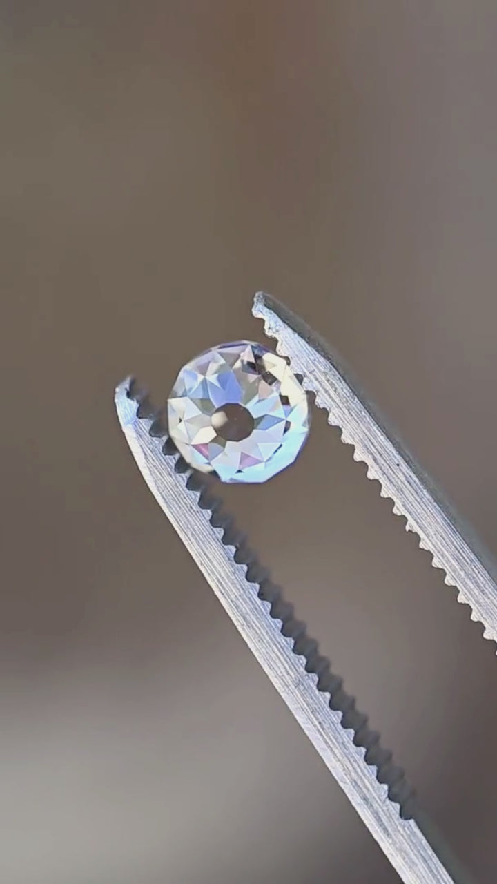 Untreated 1.06 carat Mughal cut diamond rotated between jeweler’s tweezers, showing its round proportions, open central table and broad facets flashing through changing angles.